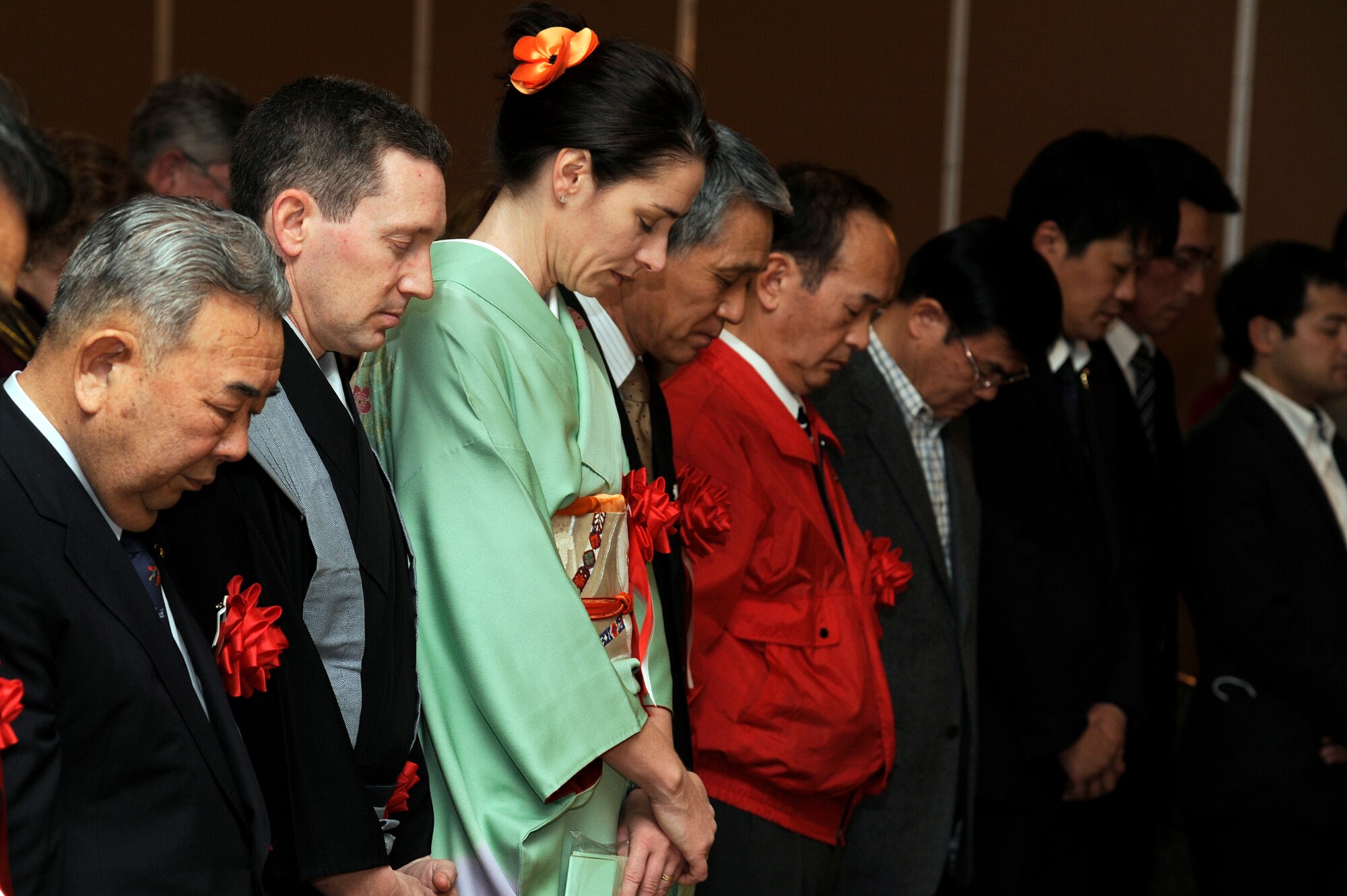 Left to right: The Honorable Kazumasa Taneichi, Misawa City mayor, U.S. Air Force Col. Michael D. Rothstein, 35th Fighter Wing commander, and his wife Jenn Rothstein along with other members of the Misawa community take a moment of silence in prayer for the victims of the March 2011 earthquake and tsunami during the 25th Annual Japan Day opening ceremony at Misawa Air Base, Japan, April 7, 2012. More than 500 people attended this year's event to enjoy modern and traditional Japanese cultural presentations. (U.S. Air Force photo by Tech. Sgt. Marie Brown/Released)
