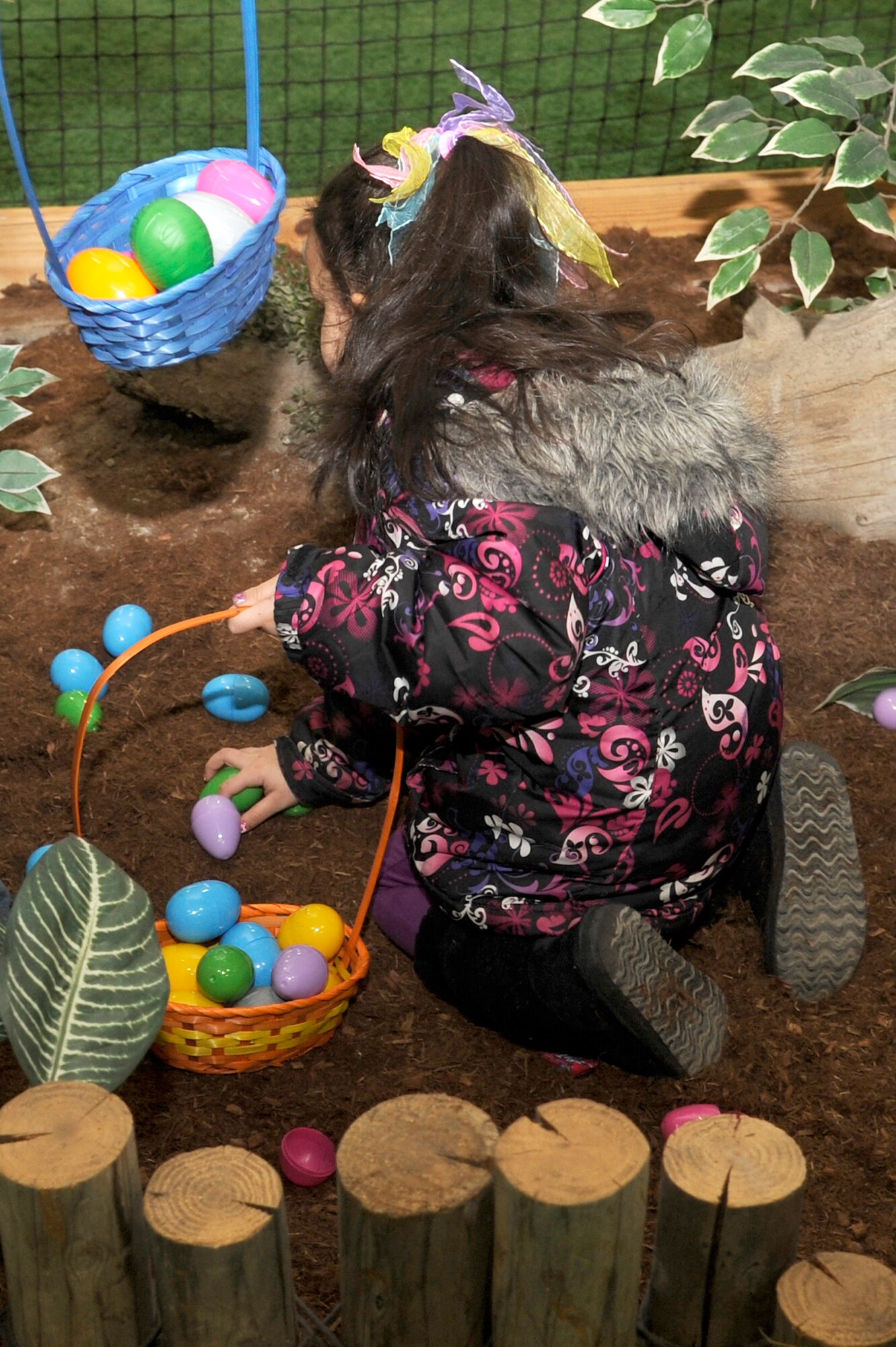 The daughter of U.S. Air Force Staff Sgt. Stacie Remy, 35th Operations Support Squadron airfield operations supervisor, picks up eggs during the 35th Force Support Squadron egg'stravaganza at Misawa Air Base, Japan, April 8, 2012. Special prize eggs were hidden for every age group that gave the children the chance of finding and winning a big prize. (U.S. Air Force photo by Tech. Sgt. Marie Brown/Released)