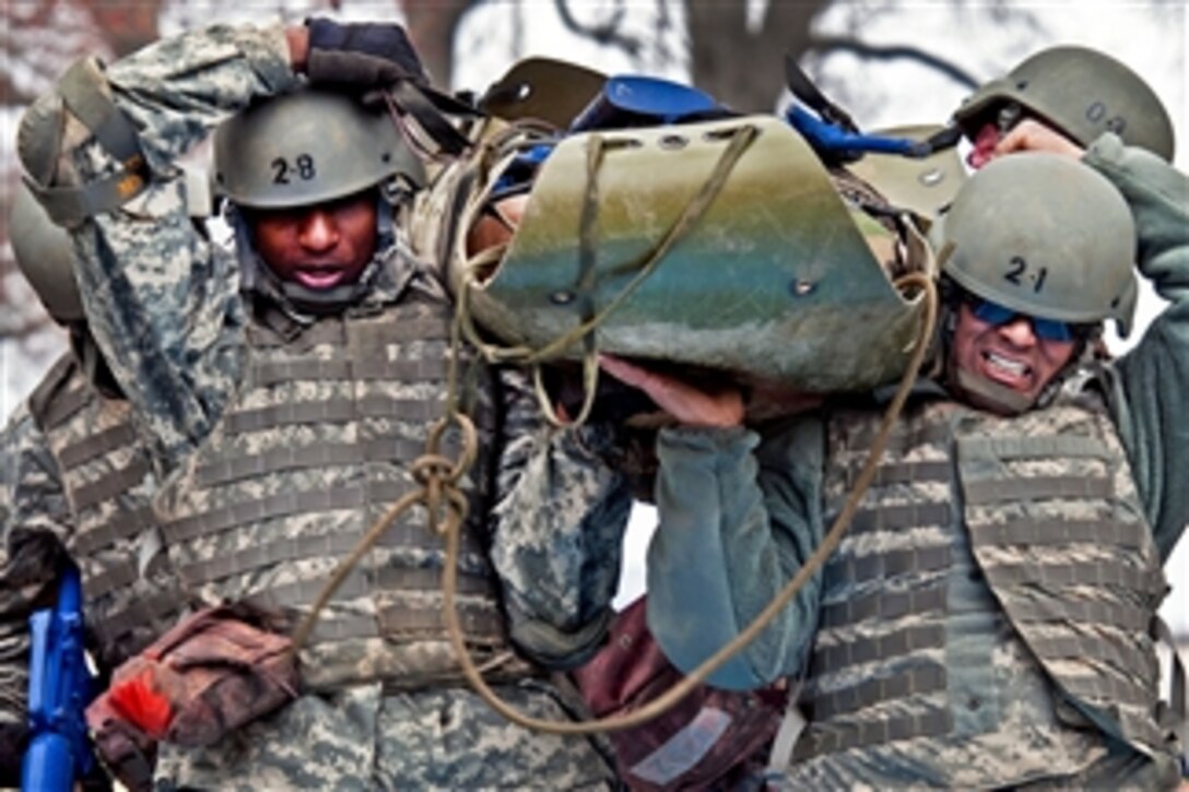 Army Staff Sgts. James Liggon, Ramon Delgado and other soldiers carry a simulated casualty through an obstacle during the physical evaluation portion of the combat lifesaver course at Fort Dix, N.J., on March 15, 2012.  Liggon and Delgado are assigned to the 316th Expeditionary Sustainment Command.  