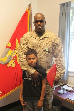 Maj. LeRon Lane, a communications officer with 2nd Marine Logistics Group and native of Havelock, N.C., poses with his oldest son after receiving the Military Outstanding Volunteer Service Medal during a ceremony aboard Camp Lejeune, N.C., April 10, 2012. Lane said he believed it was important to volunteer to show his sons how fortunate they are and to promote compassion in their communities.  (U.S. Marine Corps photo by Cpl. Katherine M. Solano)