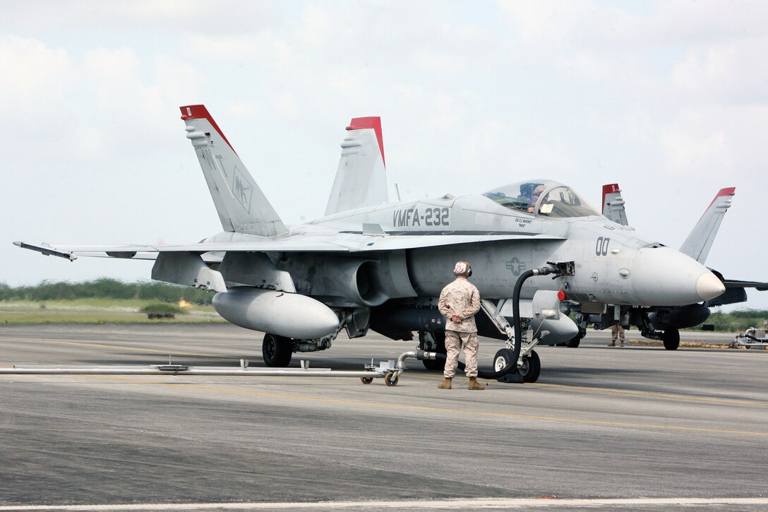 A Marine with Headquarters and Headquarters Squadron monitors the fuel intake of an F/A-18 Hornet during a hot refuel at the hot-fuel pits on Marine Corps Air Station Futenma April 10. Hot-refueling is when aircraft are refueled with engines running with the intent of getting the aircraft back in the air as quickly as possible.