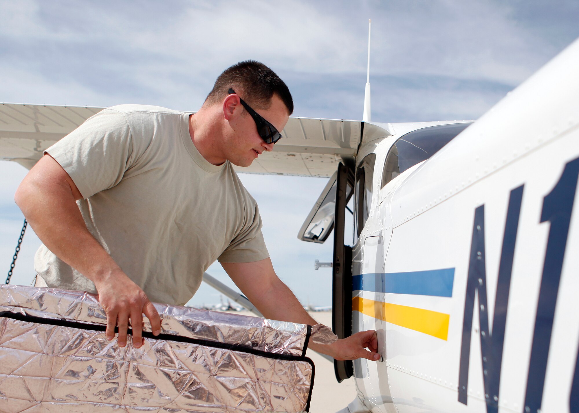 Master Sgt. Charles Layne, 461st Flight Test Squadron F-35 Aircraft Section chief, removes a sunshade visor from a compartment after performing his first solo flight in a Cessna 172 as student pilot-in-training March 29. Sergeant Layne is one of the many students at the Edwards Aero Club who now has the opportunity to train in the newly acquired Cessna 172 SP with a Garmin G1000 glass cockpit. (U.S. Air Force photo by Jet Fabara)