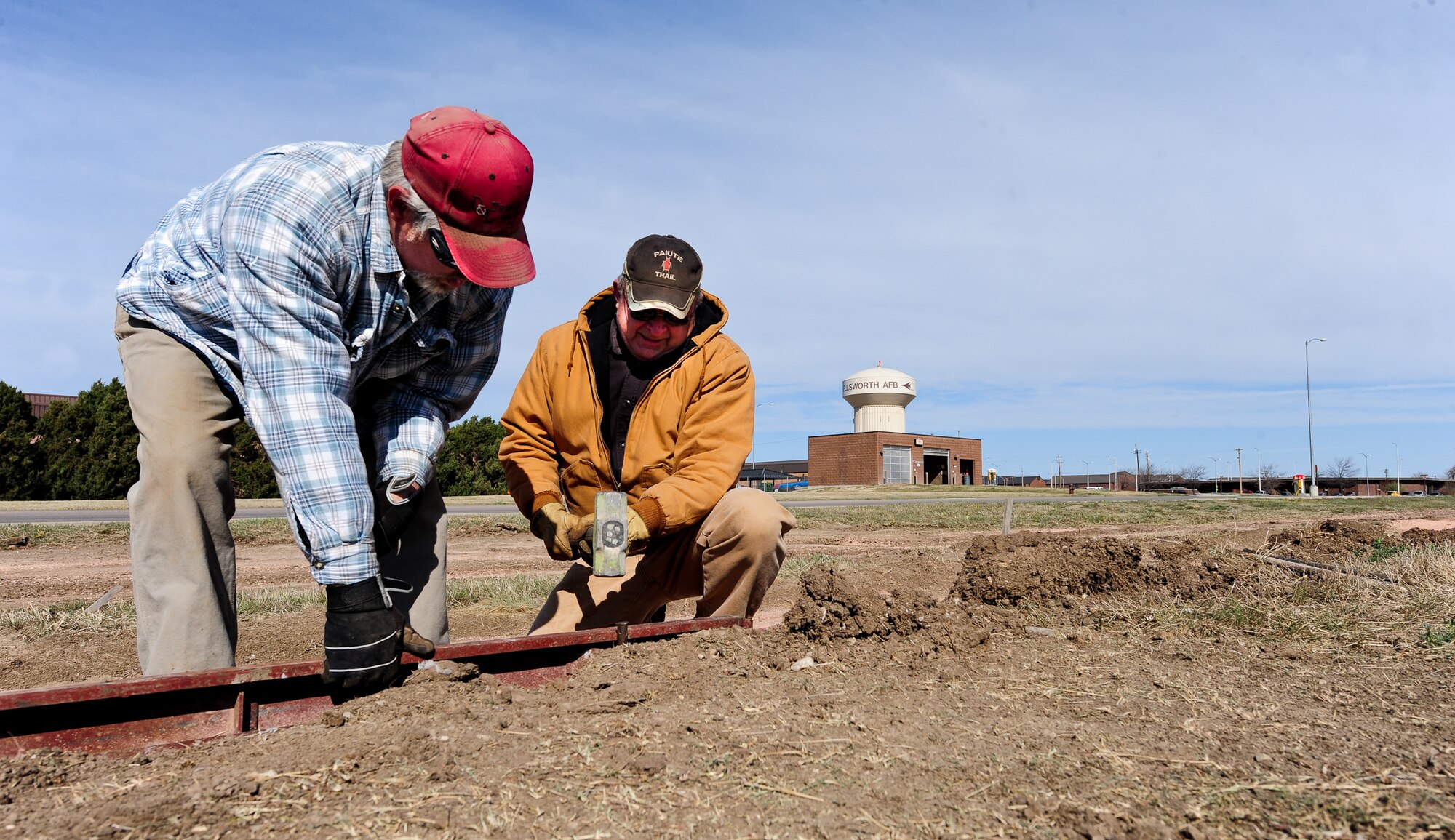 Kevin Holman (left) and William Henke, 28th Civil Engineer Squadron heavy equipment operators, set up the outline railing for a new sidewalk at Ellsworth Air Force Base, S.D., April 4, 2012. Once finished on May 1, 2012, the sidewalk will run from Dakota’s Club to Prairie View Estates. (U.S. Air Force photo by Airman 1st Class Alystria Maurer/Released)
