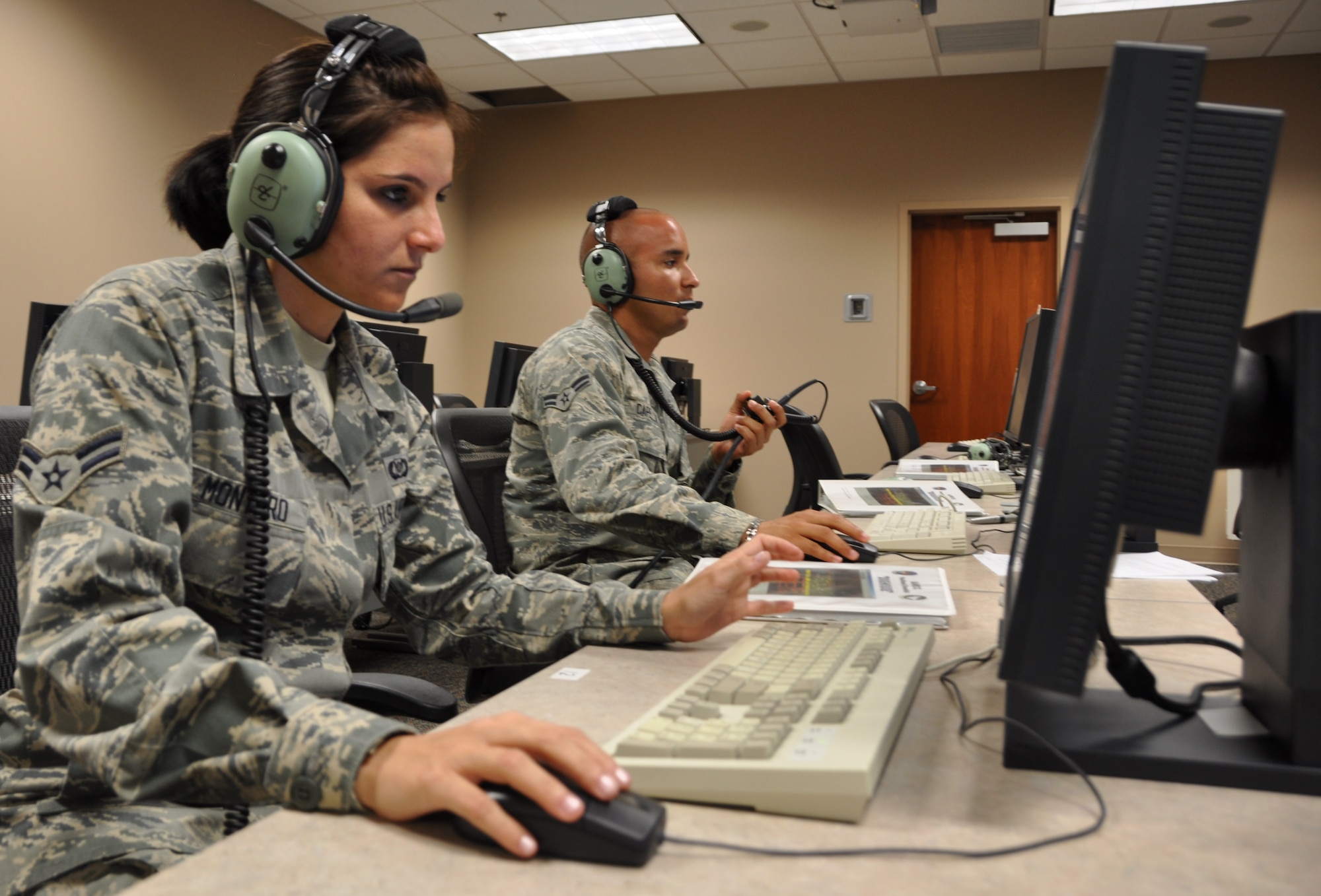 Airman 1st Class Lizandra Montero and Airman 1st Class Luis Capella, both 325th Air Control Squadron pilot simulator driver, practice drills April 10. (U.S. Air Force photo by Senior Airman Rachelle Elsea)