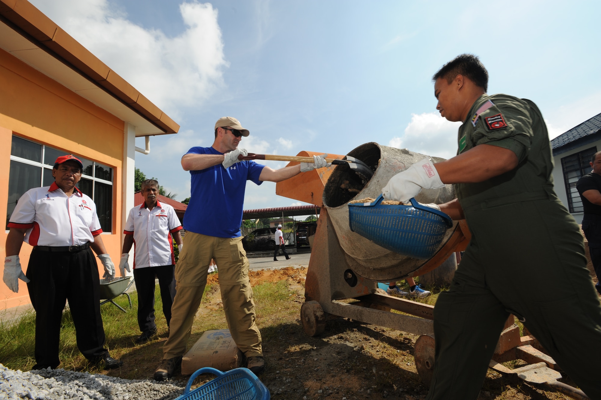 Lt. Col. Andy Shobe (center), 67th Fighter Squadron detachment commander from the 18th Wing at Kadena Air Base, Japan, shovels rock into a concrete mixer as a Royal Malaysian Air Force member and chairmen of the  Pembangunan Anak-Anak Yatim Bekas Perajurit Malaysian orphanage in Kulim stand ready to assist April 8, 2012. More than 50 U.S. Air Force and RMAF members spent the day mixing and pouring concrete to create a multi-use sports court at the orphanage as part of a humanitarian construction project  held during Cope Taufan 2012.  Exercise Cope Taufan 12 is a Pacific Air Forces sponsored exercise involving dissimilar basic fighter maneuver and dissimilar air combat tactics training with the U.S. and Royal Malaysian Air Forces at Tudm Butterworth, Malaysia, 4-13 Apr 12.(U.S. Air Force photo/Master Sgt. Matt Summers)