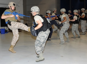 U.S. Marine Corps Captain Ronald Blaze, left, Norfolk Naval Station Security Forces Unit executive officer, warms up with U.S. Air Force Senior Airman Corie Flores, right, 633rd Security Forces Squadron patrolman, during a Krav Maga course at Langley Air Force Base, Va., April 7, 2012. During the course students are taught to respond to attacks in the quickest and most efficient way. (U.S. Air Force photo by Airman 1st Class Teresa Cleveland/Released)