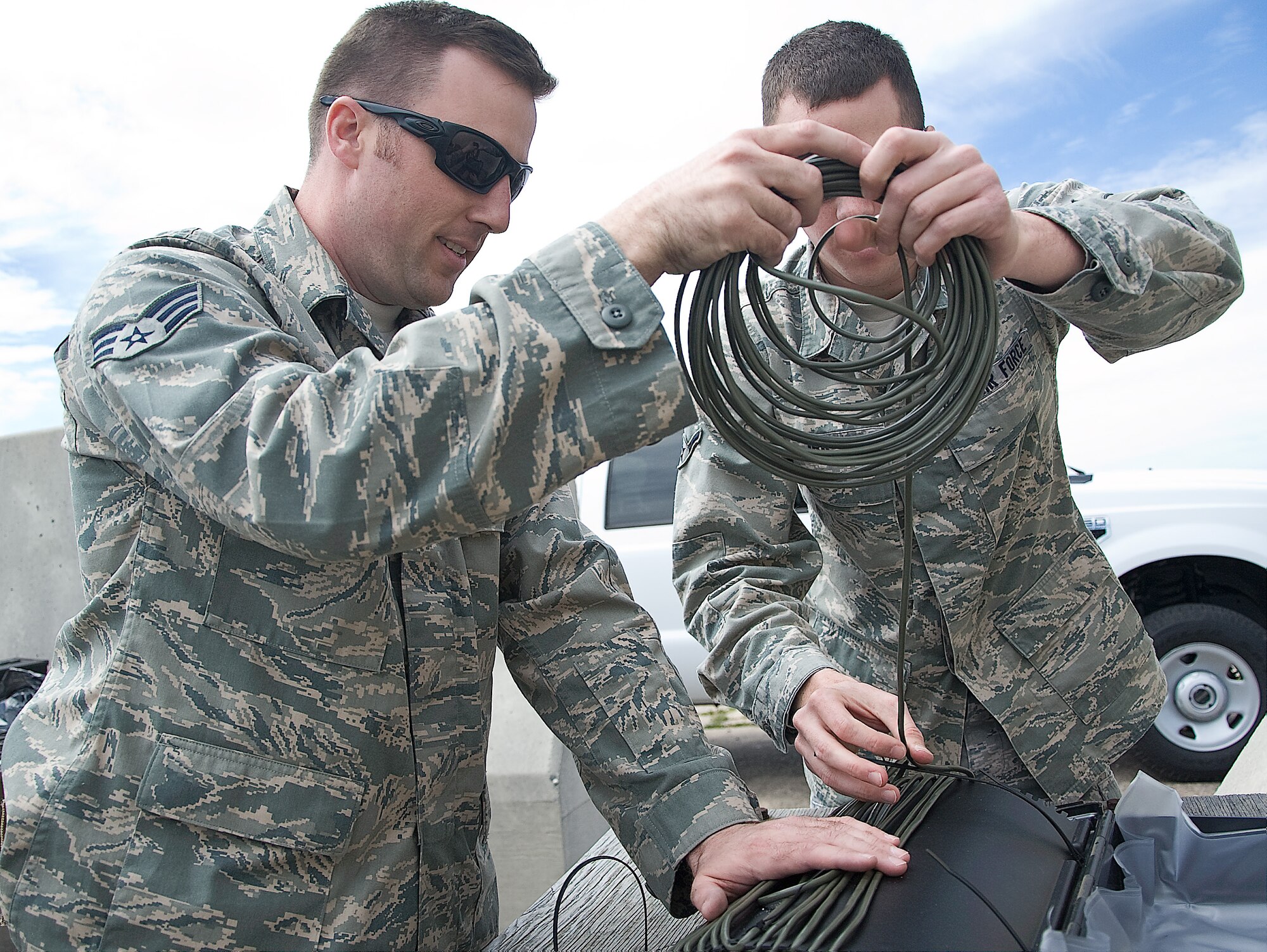Senior Airman Gregg Lowry, left, and Airman Kyle Irr, both explosive ordnance disposal technicians with the 436th Civil Engineer Squadron, string detonation cord around a ‘Boot Banger’, which are typically used to open vehicles’ trunks on vehicles April 5, 2012, at the EOD range on Dover Air Force Base, Del. The detonation cord is filled with condensed explosive powder, which burns at 23,000 feet per second. Since water is incompressible, it shoots the water at high speeds, making these types of detonations useful for disarming explosives. (U.S. Air Force photo by Senior Airman Jacob Morgan)