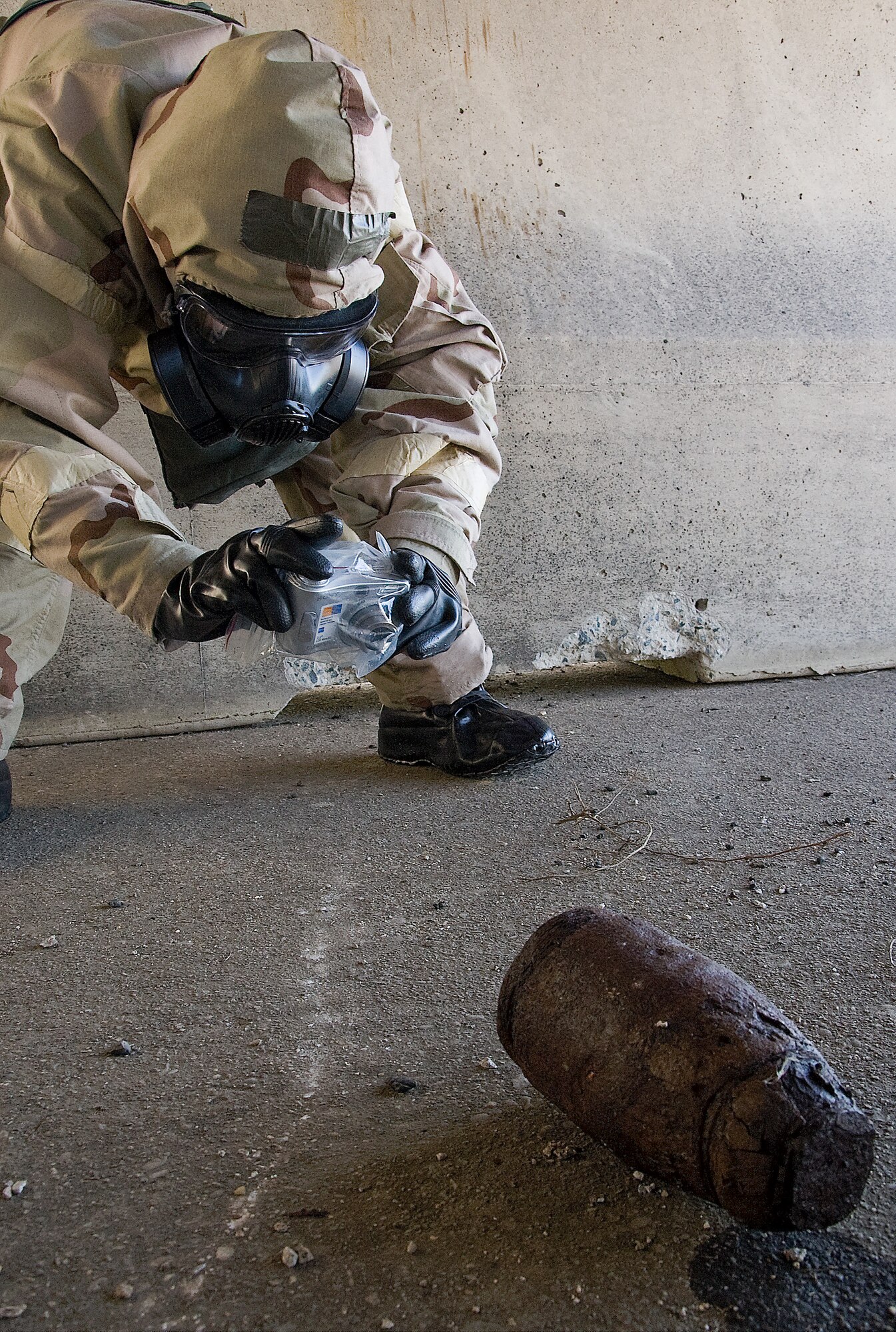 Staff Sgt. Sue Bostic, an explosive ordnance disposal craftsman with the 436th Civil Engineer Squadron, takes pictures of a simulated chemical explosive round during an exercise March 27, 2012, at the EOD range at Dover Air Force Base, Del. (U.S. Air Force photo by Senior Airman Jacob Morgan)