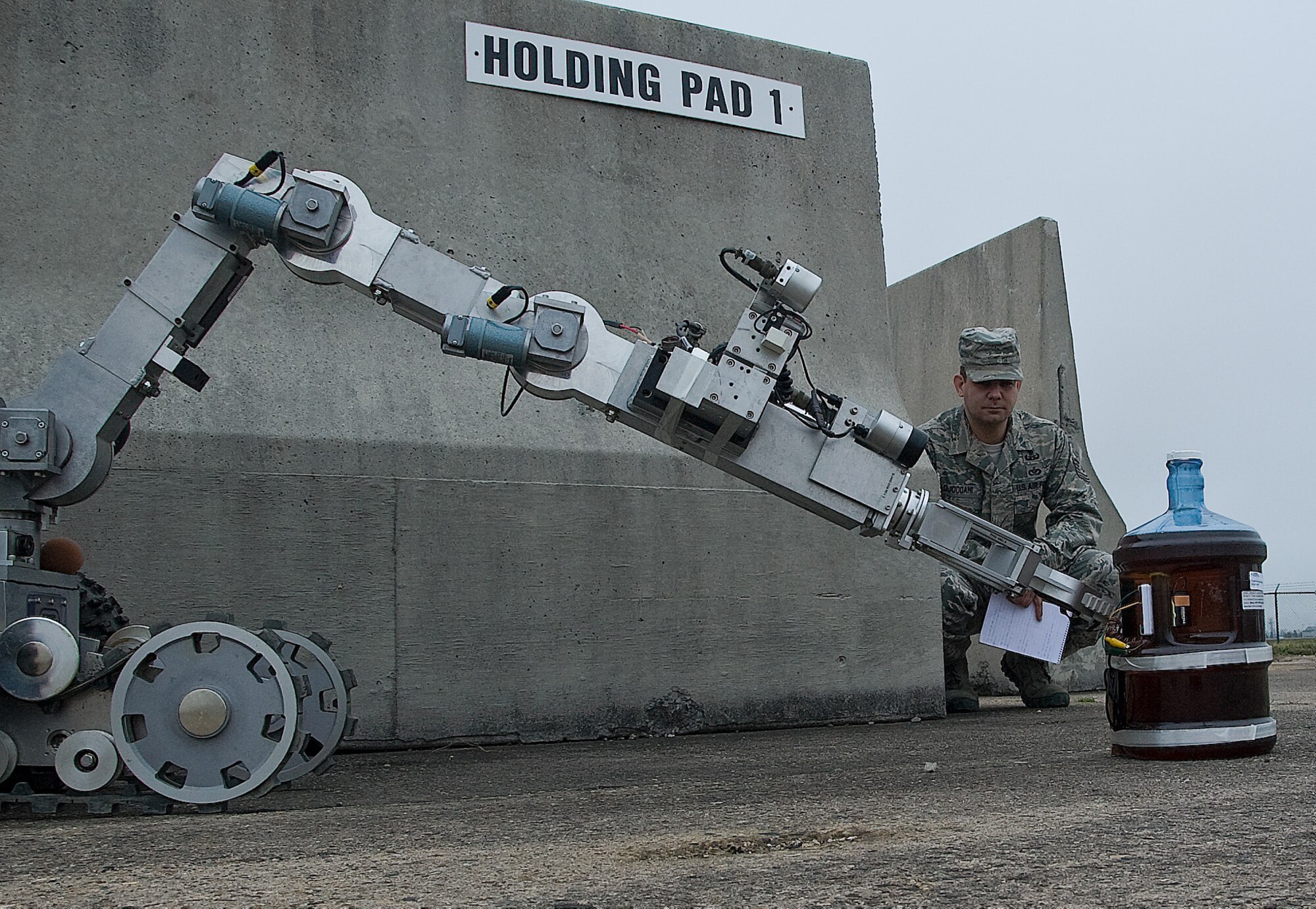 Tech. Sgt. Christopher Adjoodani, an explosive ordnance disposal craftsman with the 436th Civil Engineer Squadron, observes the F6 robot during a training exercise March 20, 2012, at the EOD range on Dover Air Force Base, Del. Staff Sgt. Sue Bostic, an EOD craftsman with the 436th CES, was driving the robot during this exercise to disable a simulated chemical weapon. (U.S. Air Force photo by Senior Airman Jacob Morgan)