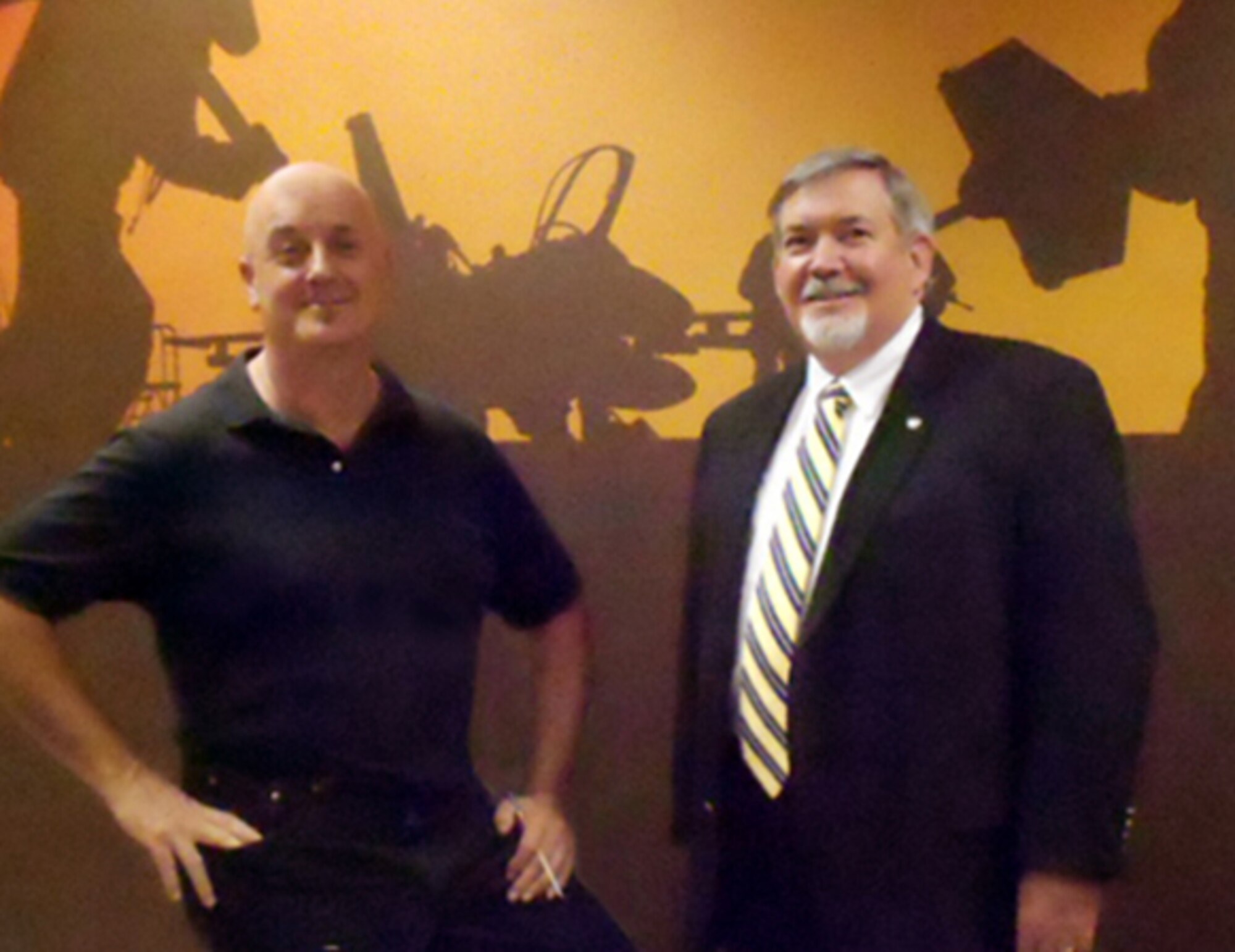 Dan Harman, left, Air Force Safety Center graphic artist and designer, shares the satisfaction of a job well done with Air Force Chief of Ground Safety Bill “Top” Parsons. Harman, who will retire April 30 with 23 years of federal service, was asked to create the mural as a visual reminder that ground safety impacts everyone, on and off duty. (U.S. Air Force photo by Lt. Col. Cindi Feldwisch)