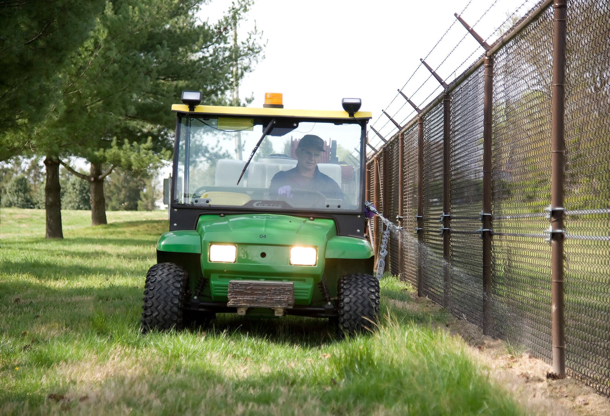 Jerry Pawluk, pest technician of pest management with the 436th Civil Engineer Squadron, sprays herbicide on the fence line April 4, 2012, at Dover Air Force Base, Del. Pawluk must spray for security purposes. (U.S. Air Force photo by Adrian R. Rowan)