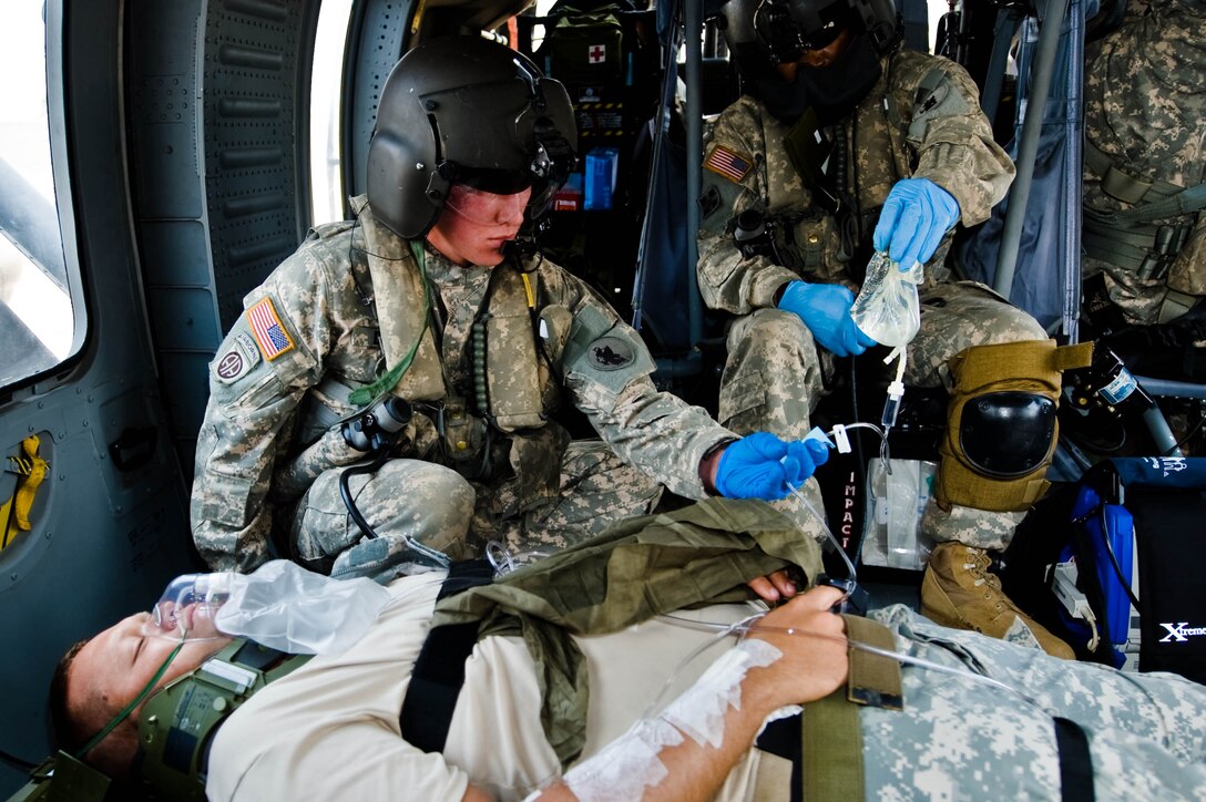 SOTO CANO AB, Honduras -- Sergeant First Class Phillip Smith, 1-228 Aviation Regiment Charlie company First Sergeant, ensures fluids are flowing properly to the simulated patient during in-flight care aboard a MEDEVAC flight during an exercise here recently. (U.S. Air Force photo by 1st Lt. Christopher Diaz)
