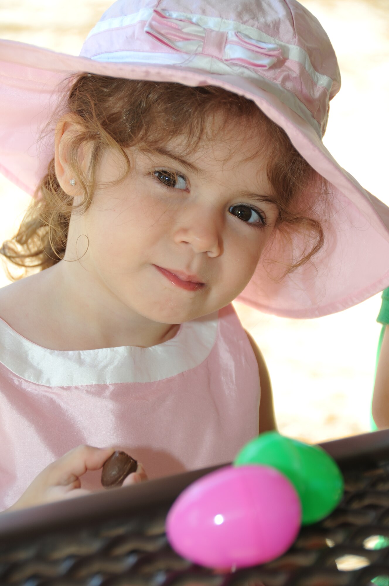 Chloe Earhart, 3, daughter of Petty Officer Chris and Daynell Earhart, Center for Naval Aviation Technical Training Unit Keesler, eats candy from the plastic eggs she retrieved during the Easter egg hunt at the marina park, April 7, 2012, at Keesler Air Force Base, Miss.  The egg hunt, preceded by a parade, was hosted by Keesler’s Outdoor Recreation Center.  (U.S. Air Force photo by Kemberly Groue)