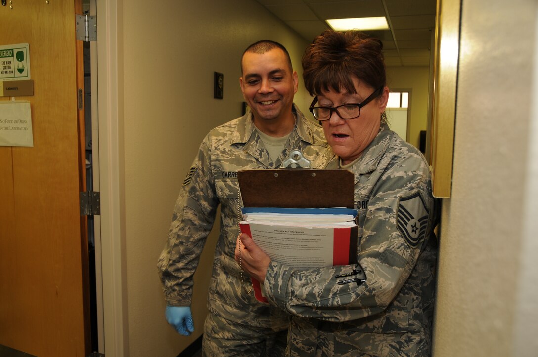 TSgt Michael Carreon has MSgt Janet Castillo sign in for immunizations during her PHA.