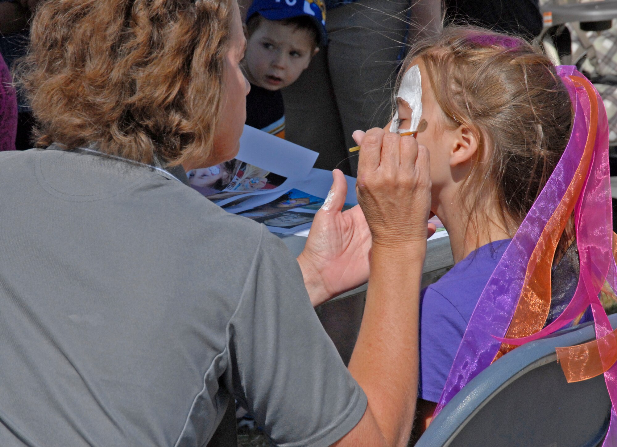 Throughout the Play Day in the Park event, children lined up to have their faces painted. Face painting was just one of the many activities geared for children at the event. The event aimed to provide a family-friendly event where both children and adults could learn about child abuse prevention and celebrate the Month of the Military Child. (Air Force Photo by Laura Mowry)