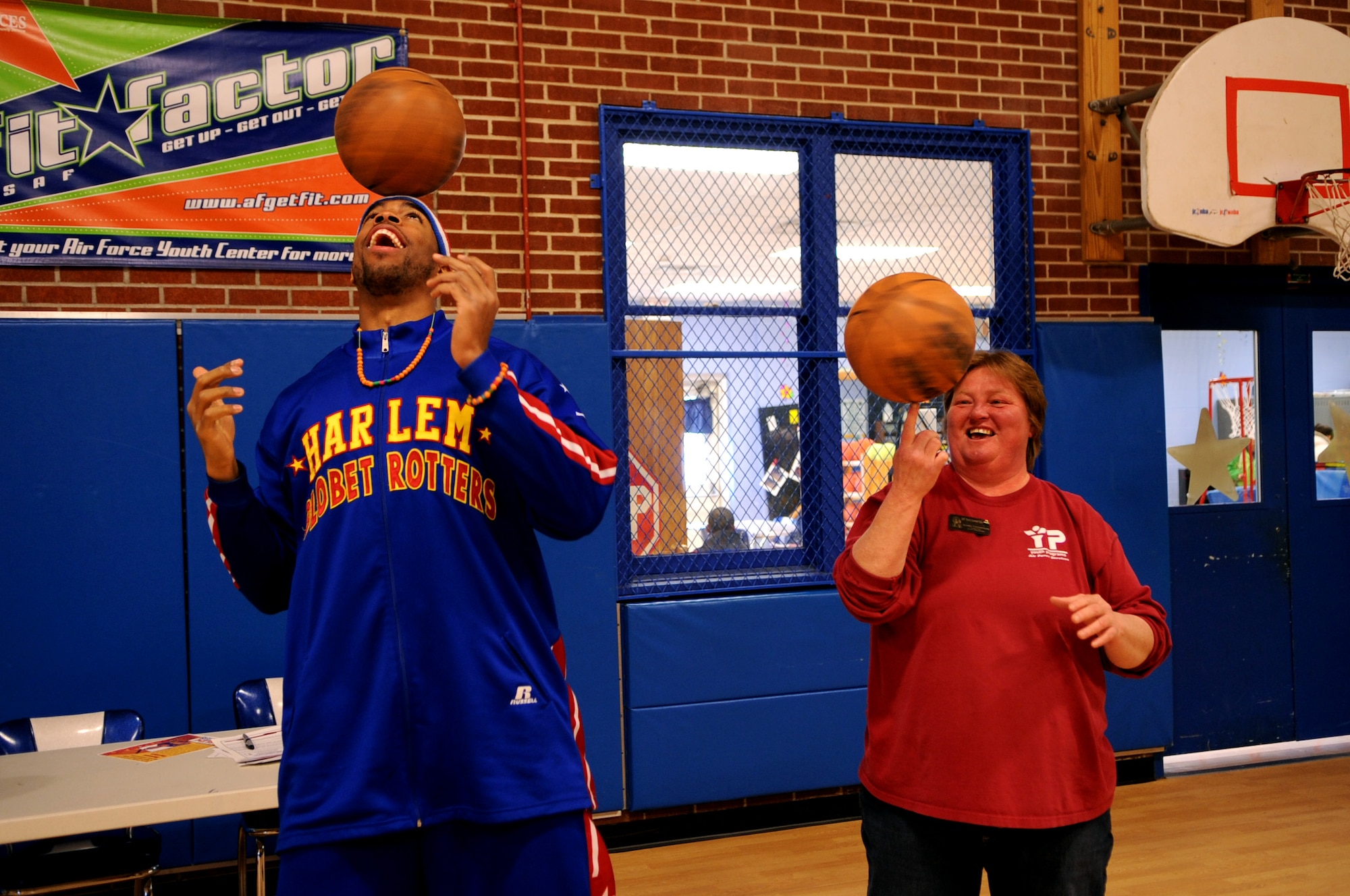 Harlem Globetrotter Hammer Harrison competes in a basketball spin competition with Dawn Thompson at the Youth Center on Grand Forks Air Force Base, N.D., on April 9, 2012. Hammer came to GFAFB to motivate and educate children with the program “C.H.E.E.R. For Character” designed by the Globetrotters. This program helps children become better prepared for challenges they will face as young adults. (U.S. Air Force photo by Staff Sgt. Amanda Grabiec)