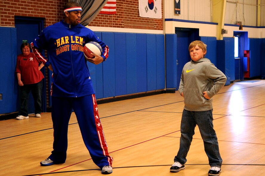 Harlem Globetrotter Hammer Harrison interacts with a child at the Youth Center on Grand Forks Air Force Base, N.D., on April 9, 2012. Hammer came to GFAFB to motivate and educate children with the program “C.H.E.E.R. For Character” designed by the Globetrotters. This program helps children become better prepared for challenges they will face as young adults. (U.S. Air Force photo by Staff Sgt. Amanda Grabiec)