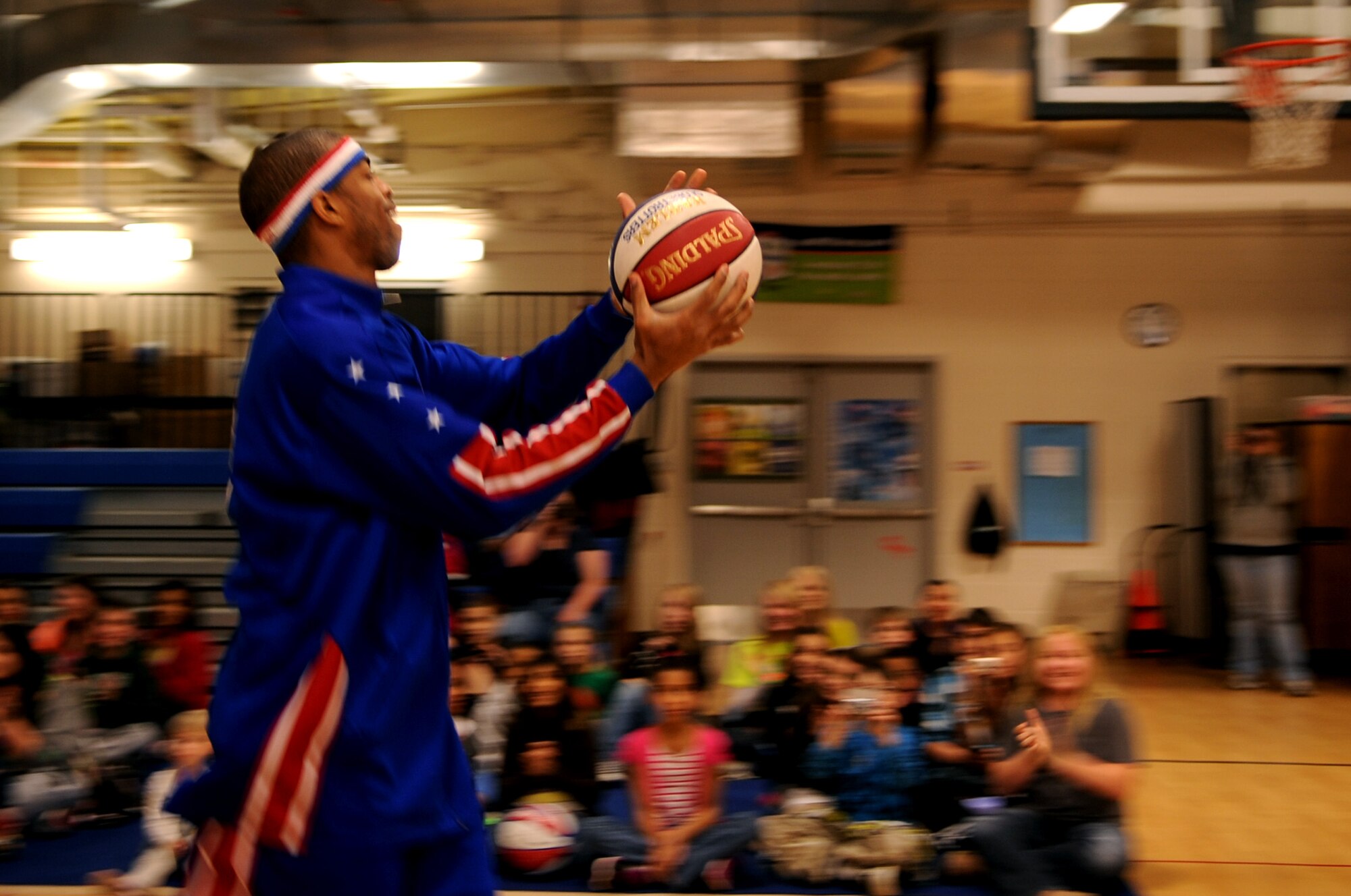 Harlem Globetrotter Hammer Harrison makes an entrance at the Youth Center on Grand Forks Air Force Base, N.D., on April 9, 2012. Harrison came to GFAFB to motivate and educate children with the program “C.H.E.E.R. For Character” designed by the Globetrotters. This program helps children become better prepared for challenges they will face as young adults. (U.S. Air Force photo by Staff Sgt. Amanda Grabiec)