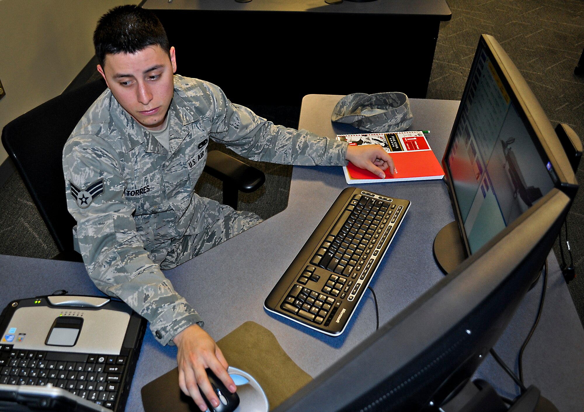Senior Airman Derek Torres, of the 57th Aircraft Maintenance Squadron, at Nellis Air Force Base, Nev., familiarizes himself with the F-35 Joint Strike Fighter using the desktop virtual-reality aircraft systems maintenance trainer, as well as a laptop loaded with joint technical data used for flight line operations. The 17-day weapons familiarization class was the first-ever weapons course completed since Eglin’s F-35 Academic Training Center began commencement of formal training Mar 19. The ATC is a first-of-its-kind facility for F-35 pilot and maintenance training.  (U.S. Air Force photo/Maj. Karen Roganov)