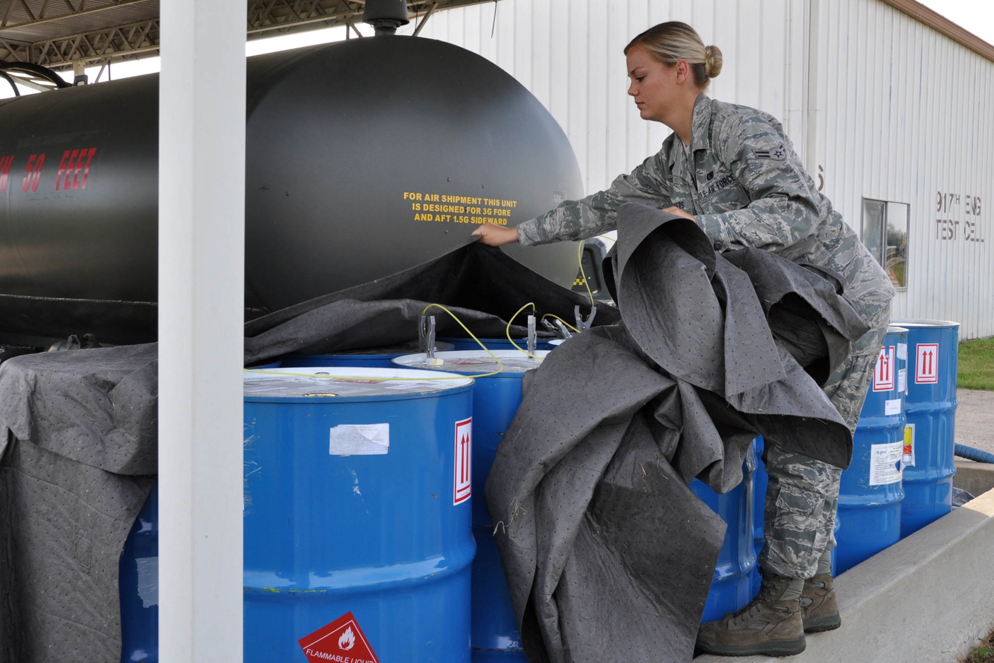 Airman 1st Class Rachel Rodgers, a fuels distribution operator assigned to fuels distribution with the 2nd Logistics Readiness Squadron, removes protective covers off of 15 barrels of JP-8/ATJ 50/50 blended fuel at the test cell on Barksdale Air Force Base, La., March 27, 2012. Rodgers was part of a multi-unit group of Active Duty and Reserve Airmen as well as civilian engineers who were preparing to test a new fuel mixture in a TF34 jet engine, which is military turbofan engine used on the A-10 Thunderbolt II. (U.S. Air Force photo by Master Sgt. Jeff Walston) 