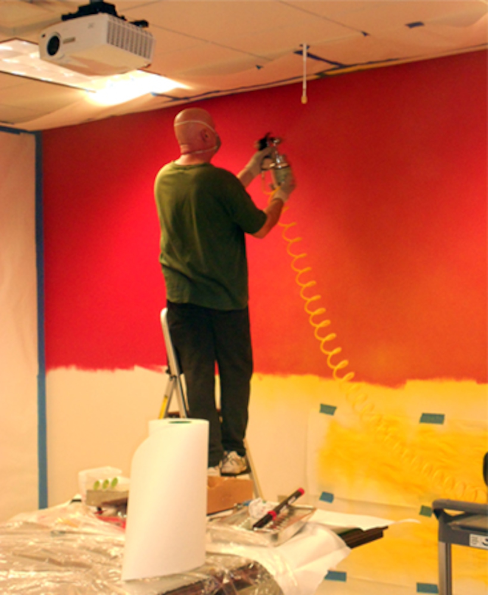 Dan Harman, Air Force Safety Center graphic artist and designer, prepares the background for a mural to cover 153 square feet in the Ground Safety Division conference room. Harman, who will retire April 30 with 23 years of federal service, was asked to create the mural as a visual reminder that ground safety impacts everyone, on and off duty. (U.S. Air Force photo by Lt. Col. Cindi Feldwisch)