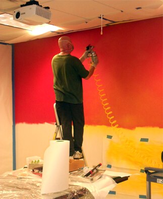 Dan Harman, Air Force Safety Center graphic artist and designer, prepares the background for a mural to cover 153 square feet in the Ground Safety Division conference room. Harman, who will retire April 30 with 23 years of federal service, was asked to create the mural as a visual reminder that ground safety impacts everyone, on and off duty. (U.S. Air Force photo by Lt. Col. Cindi Feldwisch)