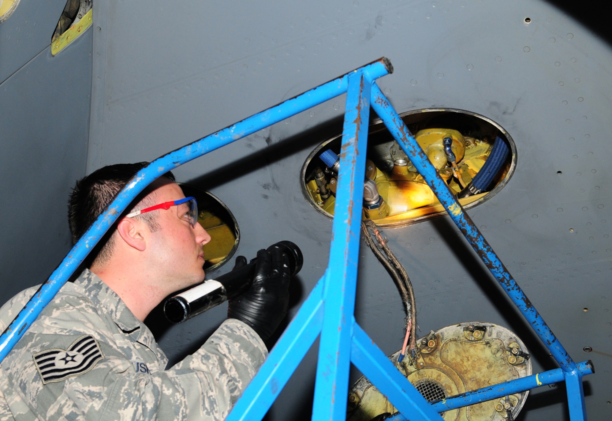 RAF MILDENHALL, England – Tech. Sgt. Blake Cushing, 100th Aircraft Maintenance Squadron flightline expeditor, looks into the dry bay at the right-side hydraulic reservoir (yellow tank) on a KC-135 Stratotanker March 28, 2012, in Hangar 814. Cushing recently earned $10,000 through the Innovative Development through Employee Awareness program, after realizing it was not necessary to drain the reservoirs after every 900 flight-hour check when filters are changed. Until recently, during the inspection process the reservoirs were drained and 36 quarts of hydraulic fluid was replaced each time. Cushing’s idea will save the Air Force more than $132,000 per year, saving both hydraulic fluid and man-hours. (U.S. Air Force photo/Karen Abeyasekere)