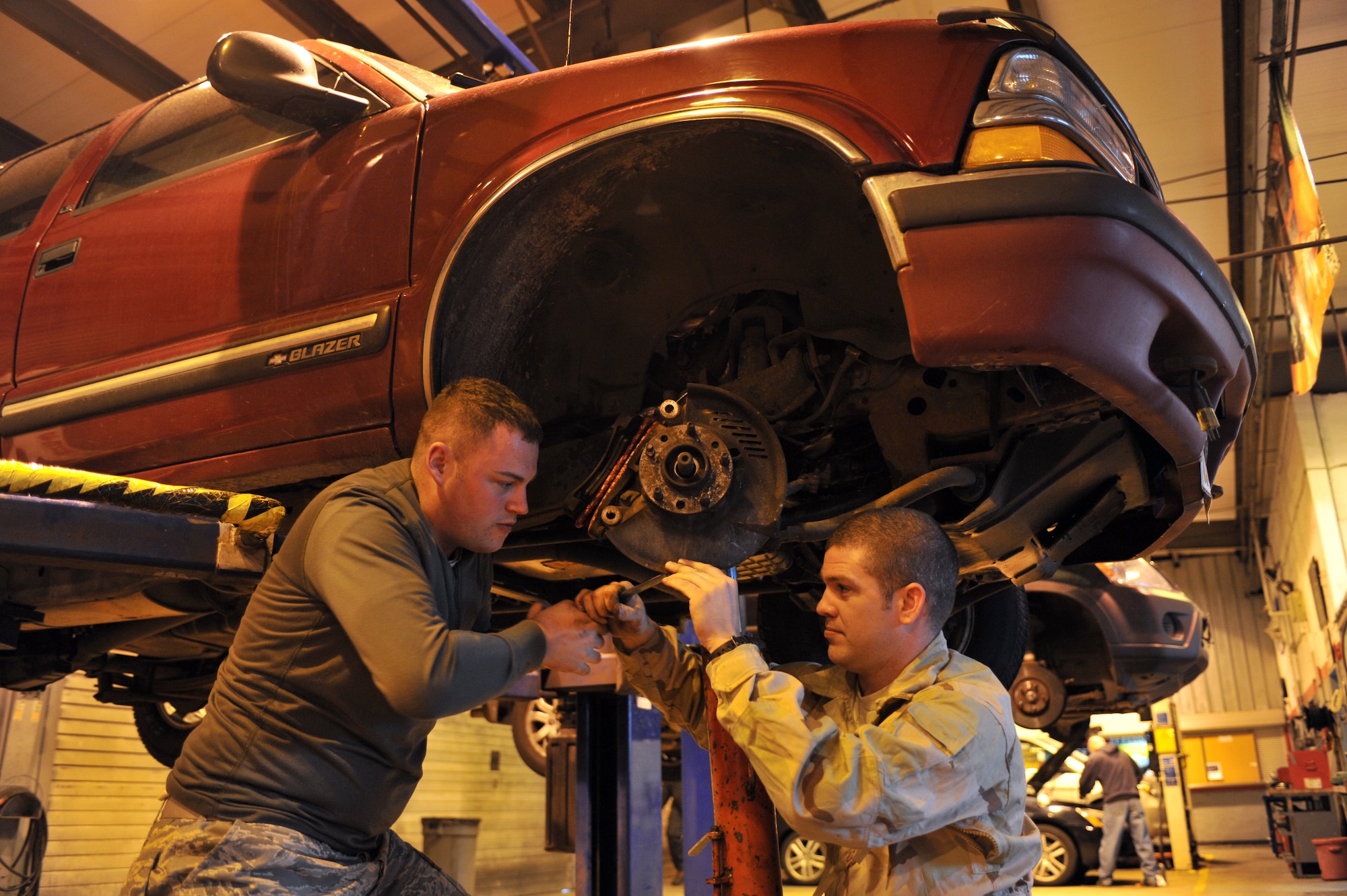 Staff Sgts. Kyle Hill and Nickolas Venteicher perform maintenance to a vehicle on Ramstein Air Base, April 9, 2012. The Auto Hobby Center is one of two auto shops on base that was reorganized to provide better customer service for military members and their families. (U.S. Air Force photo/Airman 1st Class Caitlin O'Neil-McKeown)