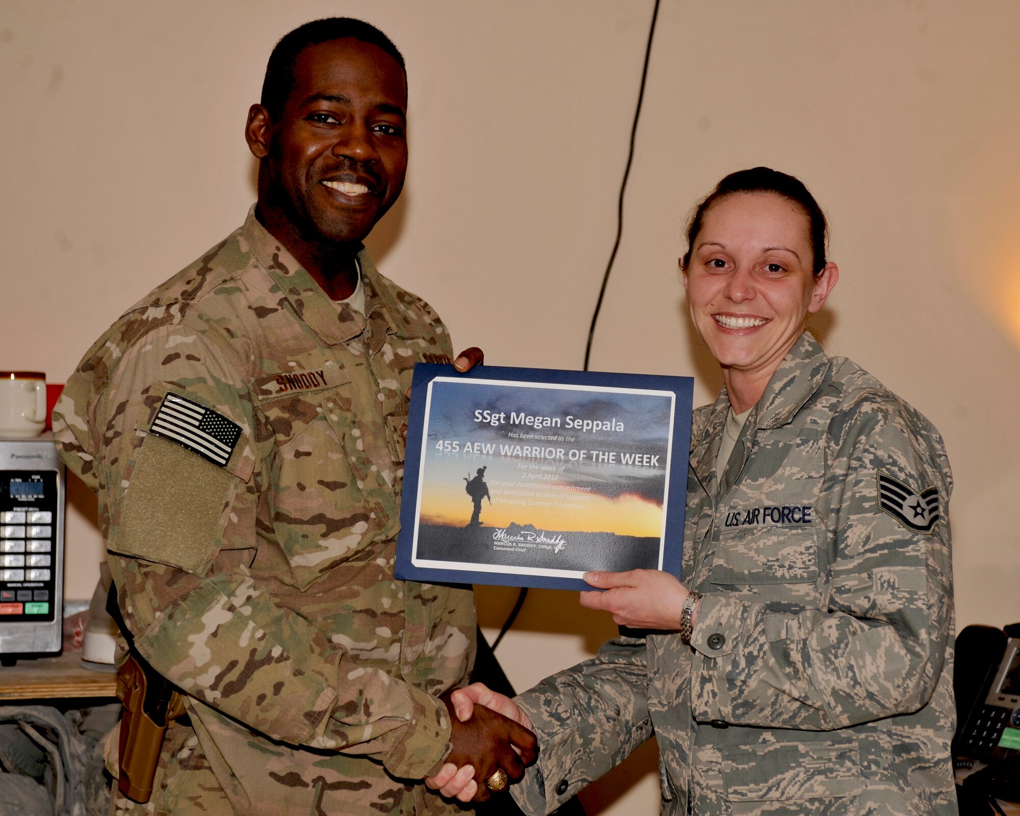 BAGRAM AIRFIELD, AFGHANISTAN-- Staff Sgt. Megan Seppala receives the Warrior of the Week award from 455th Air Expeditionary Wing Command Chief Chief Master Sgt. Marcus Snoddy at Bagram Airfield, Afghanistan, April 10, 2012. Seppala is noncommissioned officer in charge of training with the 455th Air Expeditionary Wing and earned the Warrior of the Week award for her hard work and dedication to excellence. (U.S. Air Force photo/Airman 1st Class Ericka Engblom)