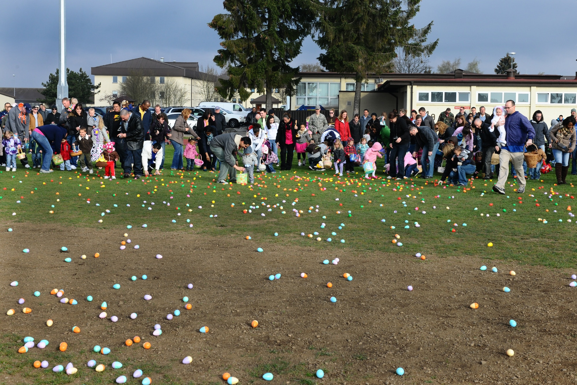 SPANGDAHLEM AIR BASE, Germany – Families gather eggs during an annual Easter egg hunt in the field behind Bldg. 149 here April 7. More than 250 children and their parents participated in the event. The event was sponsored by the local Masonic community and 52nd Force Support Squadron to support Airmen and their families. (U.S. Air Force photo by Airman 1st Class Dillon Davis/Released)