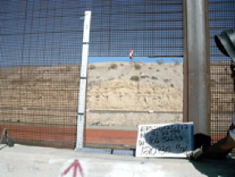 A breach in the border fence between the U.S. and Mexico.
