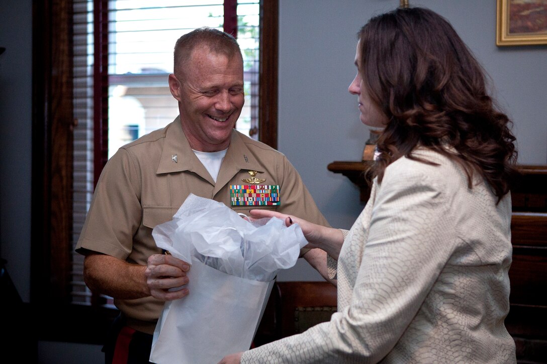 Col. Paul D. Montanus, Marine Barracks Washington commanding officer, left, presents a giftbag to Renae Clippinger, a Barracks spouse volunteer, during a volunteer appeciation cocktail at Center House April 10. The volunteers also received a certificate of appreciation for their involvement with the Barracks, Marines and their families.