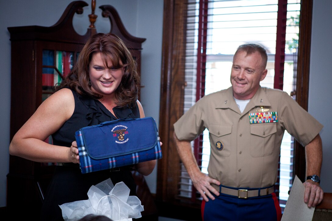 Lynnette Thompson, Marine Barracks Washington family readiness officer, left, shows off an item from the giftbag given to volunteers during a volunteer appeciation cocktail at Center House April 10. The volunteers also received a certificate of appreciation for their involvement with the Barracks, Marines and their families.