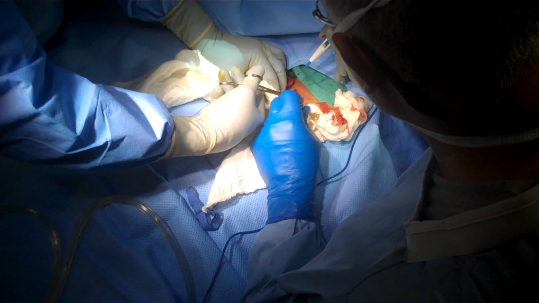 Surgeons with the Shock Trauma Platoon and Forward Resuscitative Surgery System, Surgical Company, 1st Maintenance Battalion (-) Reinforced, 1st Marine Logistics Group (Forward) perform neck surgery on a critically wounded patient at the STP/FRSS on Forward Operating Base Edinburgh, Afghanistan, April 10. For approximately three hours, the medical personnel completed blood transfusions, numerous X-Rays, three surgeries, fragment extractions and other medical procedures after an incident in nearby Musa Qa’lah in Helmand Province sent 11 critically wounded patients to the STP/FRSS.