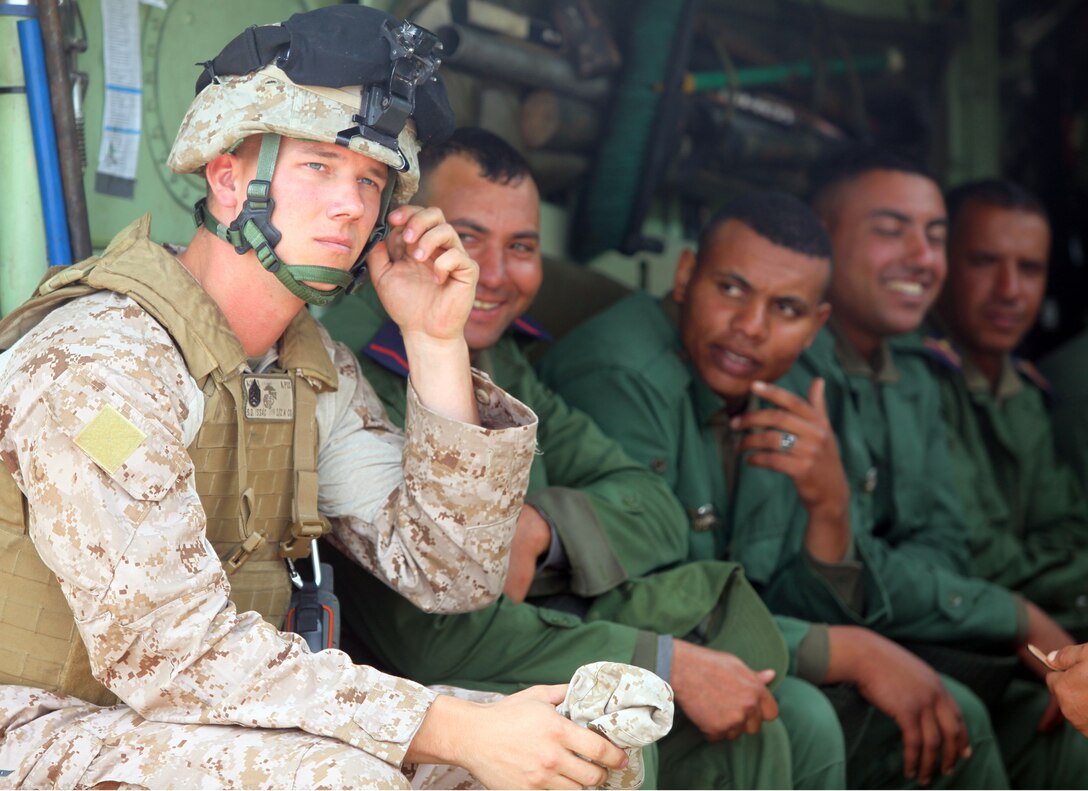 Staff Sgt. S. D. Issac who is with Alpha Company, Battalion Landing Team 1st Battalion, 2nd Marine Regiment, 24th Marine Expeditionary Unit, adjusts his gear alongside Royal Moroccan Armed Forces before giving them a ride in an Assault Amphibious Vehicle during Exercise African Lion 12, April 10, 2012. The training allowed the Marines to introduce the Moroccan troops to the unique capabilities of the AAV, which the Marines drove onto the beach that morning from the USS New York off the coast of Morocco. This exercise is the first event for the 24th MEU and Iwo Jima Amphibious Ready Group, both of which deployed in March on a regularly scheduled deployment to serve as a theater reserve and crisis response force.