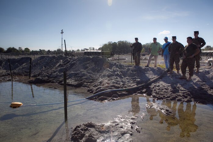 Capt. Steve L. Draper, logistics officer, Headquarters Battalion, 3rd Marine Division, shows National Defense Support Command personnel the source of raw water for use in the Tactical Water Purification System in place in Crow Valley, Philippines, for Exercise Balikatan 2012.
