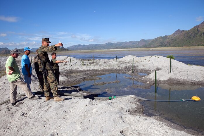 Capt. Steve L. Draper, logistics officer, Headquarters Battalion, 3rd Marine Division, shows National Defense Support Command personnel the source of raw water for use in the Tactical Water Purification System in place for the camp in Crow Valley, Philippines, for Exercise Balikatan 2012.