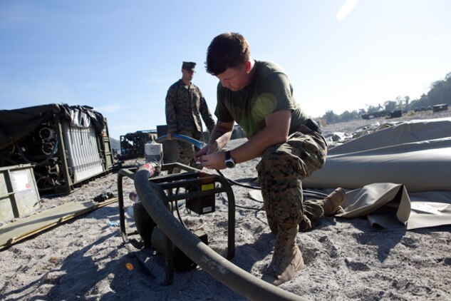 Lance Cpl. Cory B. Smith, hygiene equipment operator, Combat Logistics Battalion 3, prepares to pump clean water into an M-149 water tank in Crow Valley, Philippines, for Exercise Balikatan 2012, April 11. He used a Tactical Water Purification System to turn raw river water into potable water for the camp. "It's crucial to have a sustainable amount of water at all times," Smith said. "Before we had to wait for water trucks to come in from the locals to start purifying water, and that wasn't enough to meet our camp's needs."