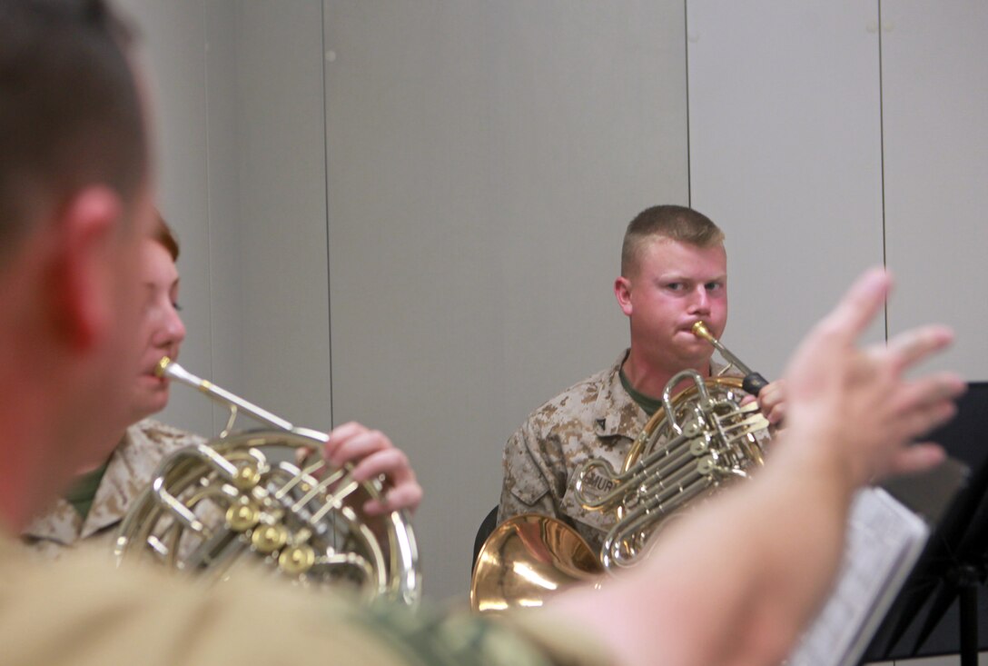 Selma, N.C., native Lance Cpl. Cameron Murray (right), a French horn player with the 2nd Marine Division Band, plays while Las Cruces, N.M., native Staff Sgt. Douglas Quinzi (foreground), a French horn player with the United States Marine Band, commonly referred to as The President’s Own, conducts a music lesson April 11.  Quinzi and others with The President’s Own gave group and individual lessons to the 2nd Marine Division Band Marines throughout the week before the two groups played together during a concert April 13.::r::::n::                Murray was excited to receive instruction from and play with members of The President’s Own at the concert.::r::::n::                “It’s going to be a great experience,” said Murray.  “It’s great music that we’re playing, and the audience is going to love it – it’s going to be a great concert.”