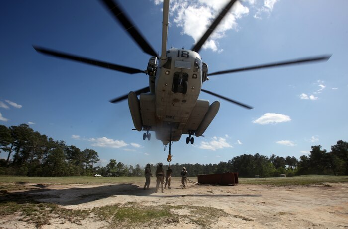 A CH-53E Super Stallion hovers over Marines with Landing Support Company, Combat Logistics Regiment 27, 2nd Marine Logistics Group as they latch simulated cargo to its underside during helicopter support training at Landing Zone Kite aboard Camp Lejeune, N.C., April 11, 2012. The purpose of the exercise was to give the company’s Marines a chance to sharpen their knowledge of their military occupational specialty.