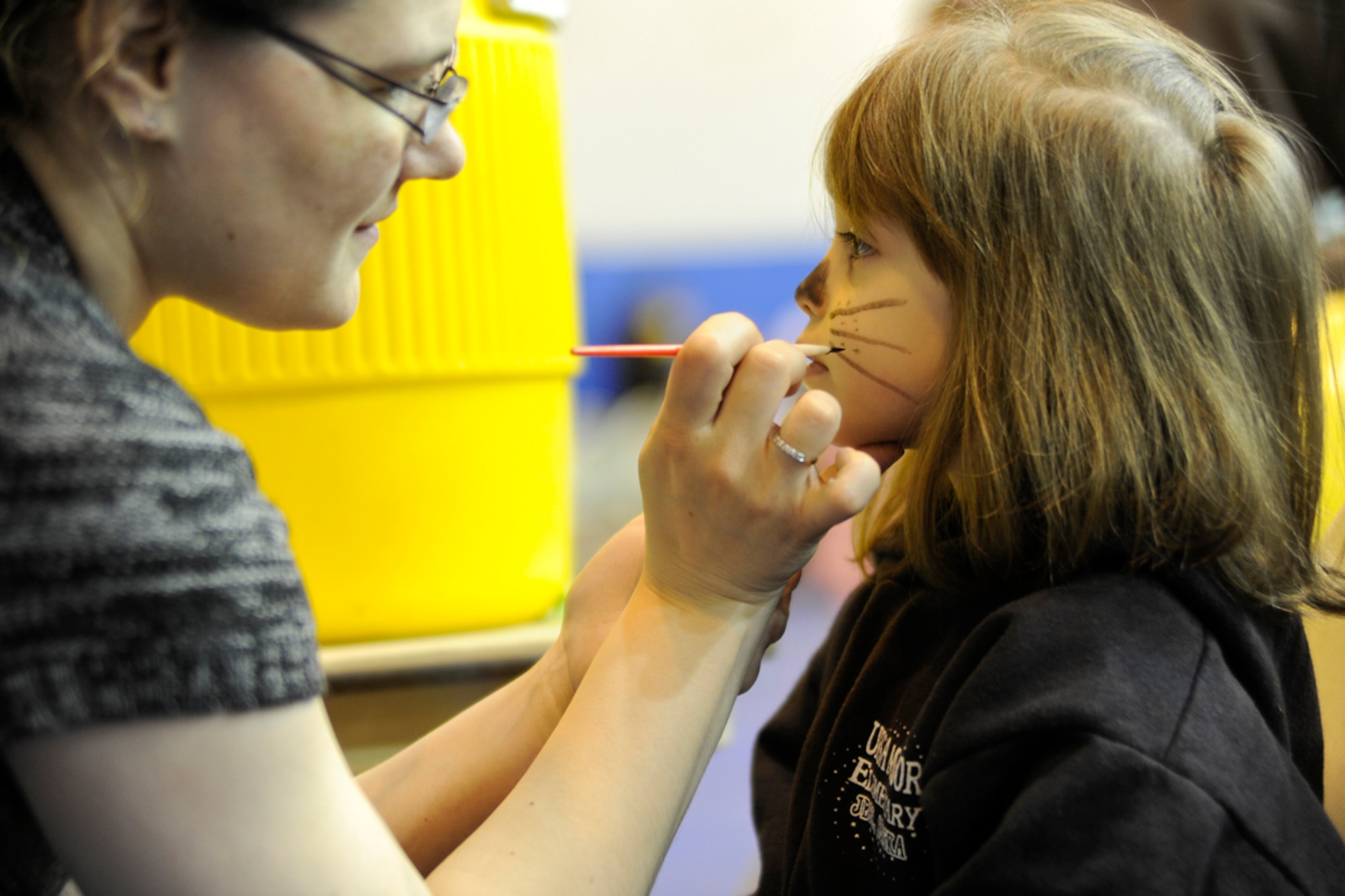 Melissa Thornton, Alaska National Guard child and youth program employee paints Isabella Salazar, age 5, during the Family Fun and Fitness Fair inside the Buckner Gym on Joint Base Elmendorf-Richardson April 7, 2012. The fair was held as part of the Month of the Military Child in conjunction with the "Easter Eggstravaganza" that was held right outside the gym. (U.S. Air Force photo/Staff Sgt. Zachary Wolf)