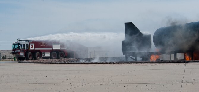 Fire protection members extinguish a simulated aircraft fire at the fire department training area at Ellsworth Air Force Base, S.D., April 9, 2012. Fire protection Airmen train to respond to and a variety of emergencies, ranging from aircraft incidents to wild fires. (U.S. Air Force photo by Airman 1st Class Kate Thornton/Released)