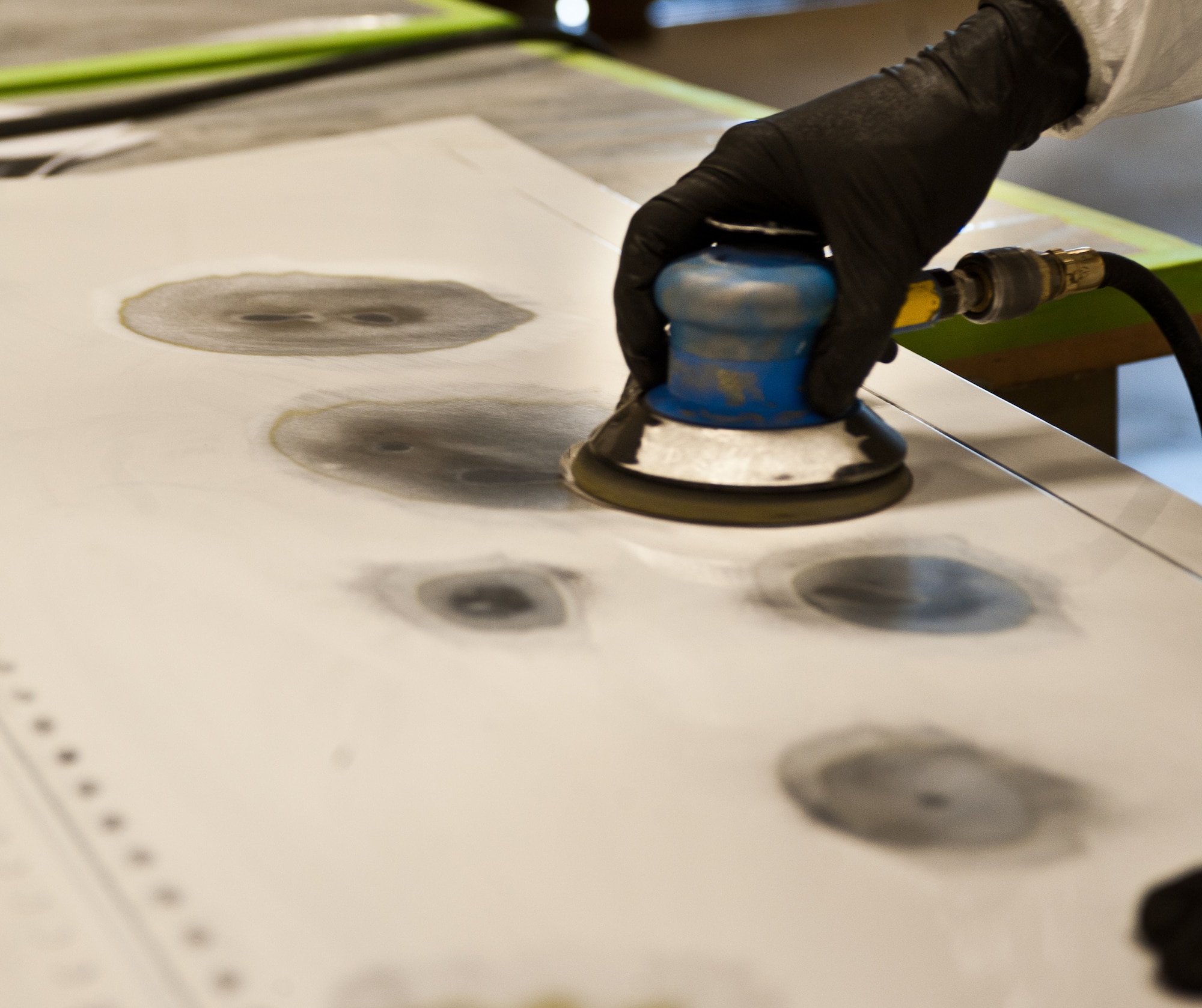 Senior Airman Spencer Hensinger, 28th Maintenance Squadron aircraft structural maintenance technician, uses an orbital sander to remove defects at Ellsworth Air Force Base, S.D., April 3, 2012. Filler is applied to dents then sanded down to maintain the integrity and smoothness of the part intact and free of flaws. (U.S. Air Force photo by Airman 1st Class Alystria Maurer/Released)