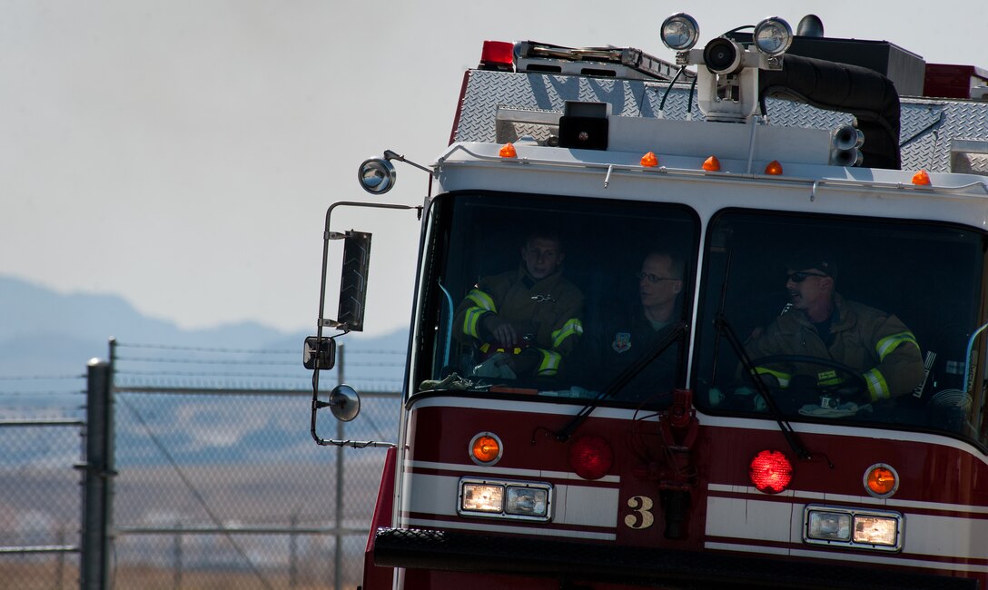 Col. Mark Weatherington, 28th Bomb Wing commander, joins Staff Sgt. Matthew Wright (left), 28th Civil Engineer Squadron fire protection crew chief, and Bill Cina, 28th CES fire protection vehicle operator, during a training exercise at the fire department training area on Ellsworth Air Force Base, S.D., April 9, 2012. The fire protection specialists train every day on different aspects of their jobs to ensure they are able and ready to respond to any emergency situation. (U.S. Air Force photo by Airman 1st Class Kate Thornton/Released)