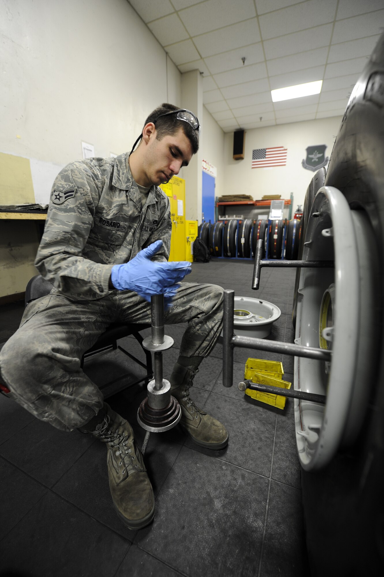 Airman 1st Class Nick Rosario, 92nd Maintenance Squadron repair journeyman, prepares a compression tool for use in the jet tire repair shop at Fairchild Air Force Base, Wash., April 5, 2012. The compression tool is used to bring each side of the rim closer, making them able to attach. (U.S. Air Force photo by Airman 1st Class Ryan Zeski/Released)