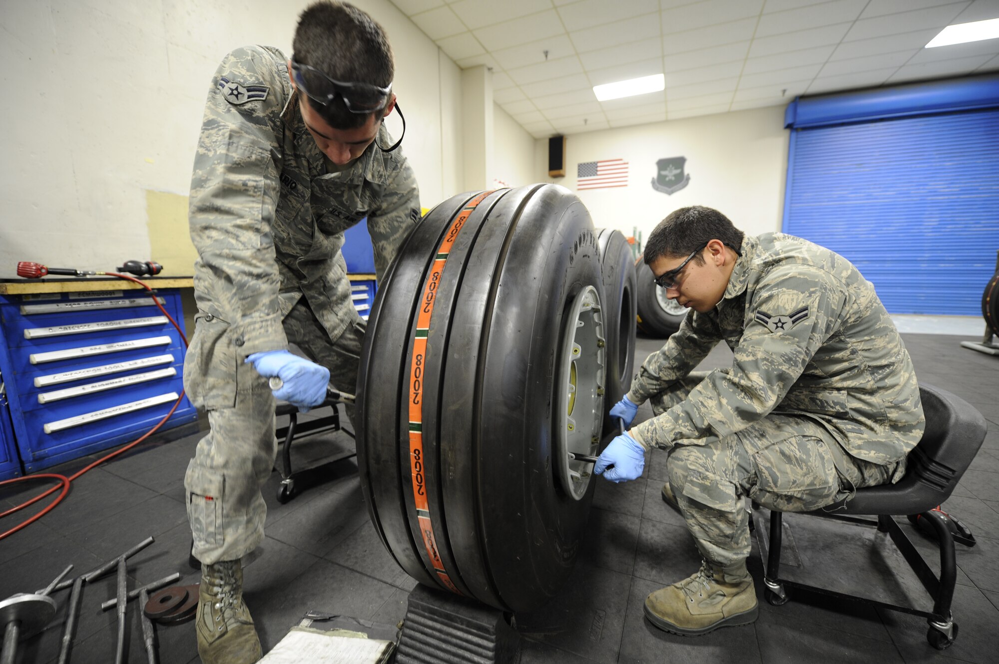 Applying high torque in the range of 1,850 to 2,040 inch-pounds of pressure, Airmen 1st Class Nick Rosario and Martin Felix Manchado, 92nd Maintenance Squadron repair journeymen, complete the final step of a rim installation at the jet tire shop at Fairchild Air Force Base, Wash., April 5, 2012. Securing a total of 18 bolts on each jet tire, requires attention to detail from both Airmen. (U.S. Air Force photo by Airman 1st Class Ryan Zeski/Released)