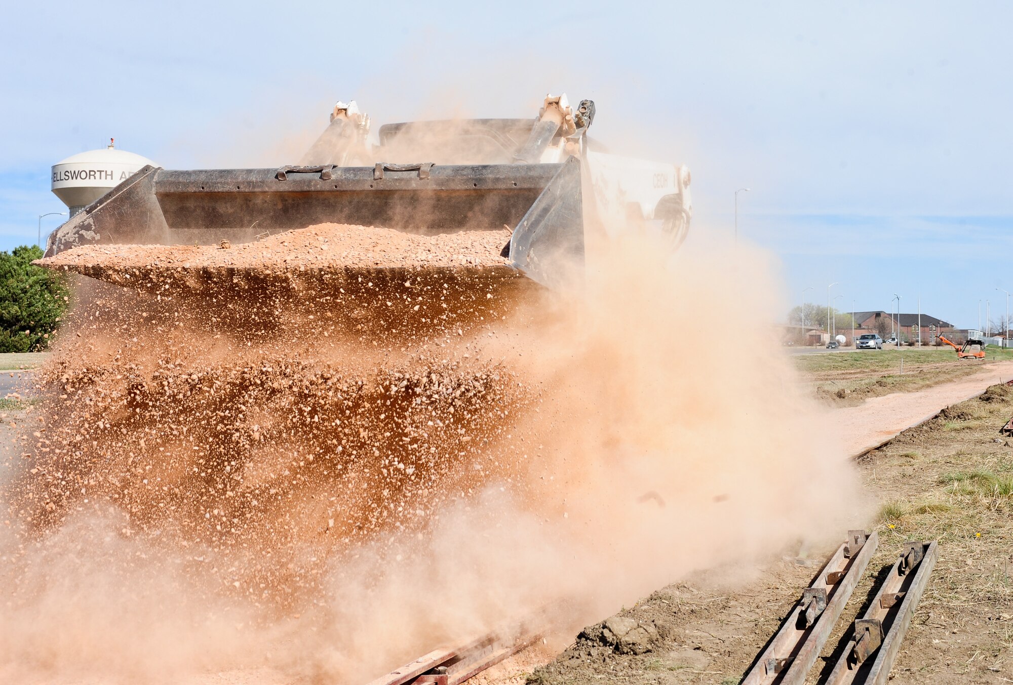 Kevin Holman, 28th Civil Engineer Squadron heavy equipment operator, drops a load of gravel on a pathway during a sidewalk construction project at Ellsworth Air Force Base, S.D., April 4, 2012. The gravel provides a strong foundation that increases the lifespan of the concrete being poured. (U.S. Air Force photo by Airman 1st Class Alystria Maurer/Released)