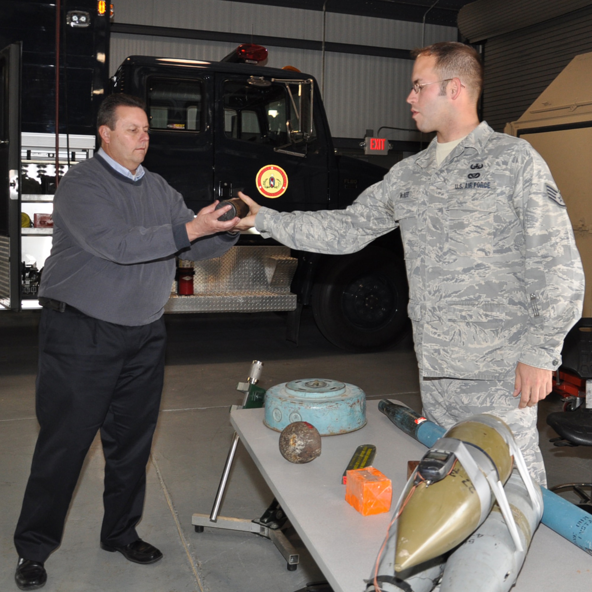 Starff Sgt. Patrick McKee, explosive ordnance disposal technician, 22nd Air Refueling Wing hands munitions to Ty Lasher, Honorary Commander to the 931st ARG group superintendent, during a tour hosted by the 22nd Mission Support Group at McConnell Air Force Base, April 11. Honorary commanders from the 931st ARG and 22nd ARW toured the squadrons and facilities operated by the 22nd MSG. McKee was showing the honorary commanders various types of military munitions and improvised explosive devices. (Air Force photo by Staff Sgt. Carrie Peasinger)