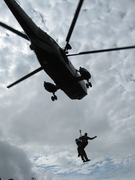 Royal Malaysian Air Force Cpl. Shahzaihar Zainol, a combat air rescueman, recovers Capt. Daniel Parrish, 67th Fighter Squadron F-15C pilot, as part of a combat search and rescue exercise during Cope Taufan 2012 at TUDM Butterworth, Malaysia, on April 11, 2012. Tech. Sgt. Robert Colliton, 18th Operations Support Squadron Survival, Evasion, Resistance and Escape specialist from Kadena Air Base, Japan, conducted a subject matter expert exchange with RMAF members during the exercise. U.S. Air Force and RMAF airmen also spent time in the jungle of northwest Malaysia refreshing their survival skills. Cope Taufan is a live-flying exercise designed around dissimilar basic fighter maneuvers and dissimilar air combat tactics training. (U.S. Air Force photo/Tech. Sgt. Robert Colliton)