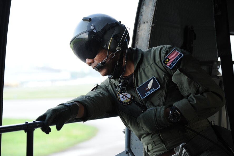 Royal Malaysian Air Force Sgt. Shahrul Naim, S-61A-4 Nuri crewman, looks out the cargo door of the helicopter during takeoff as part of a combat search and rescue exercise during Cope Taufan 2012 at TUDM Butterworth, Malaysia, on April 11, 2012. Tech. Sgt. Robert Colliton, 18th Operations Support Squadron Survival, Evasion, Resistance and Escape specialist from Kadena Air Base, Japan, conducted a subject matter expert exchange with RMAF members during the exercise. U.S. Air Force and RMAF airmen also spent time in the jungle of northwest Malaysia refreshing their survival skills. Cope Taufan is a live-flying exercise designed around dissimilar basic fighter maneuvers and dissimilar air combat tactics training. (U.S. Air Force photo/Master Sgt. Matt Summers)
